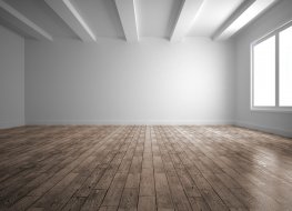 A white room with flooring, ready to be furnished