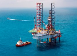 Photo of oil rig at sea with boat