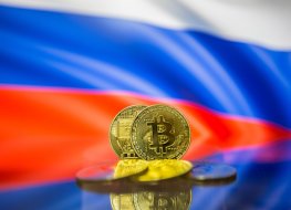 Bitcoin coins in front of a Russian flag