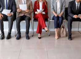 Stock photo of smartly dressed people ready for a job interview sitting in a waiting area 