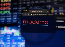 KAUFBEUREN, GERMANY - APRIL 19, 2021: Moderna company logo on a website with blurry stock market developments in the background, seen on a computer screen through a magnifying glass.