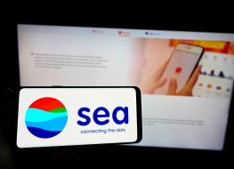 STUTTGART, GERMANY - Aug 23, 2021: Person holding mobile phone with logo of Singaporean technology conglomerate Sea Limited on screen in front of web page Focus on phone display