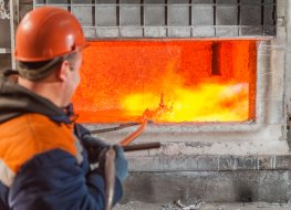 A worker melting aluminium near a furnace 